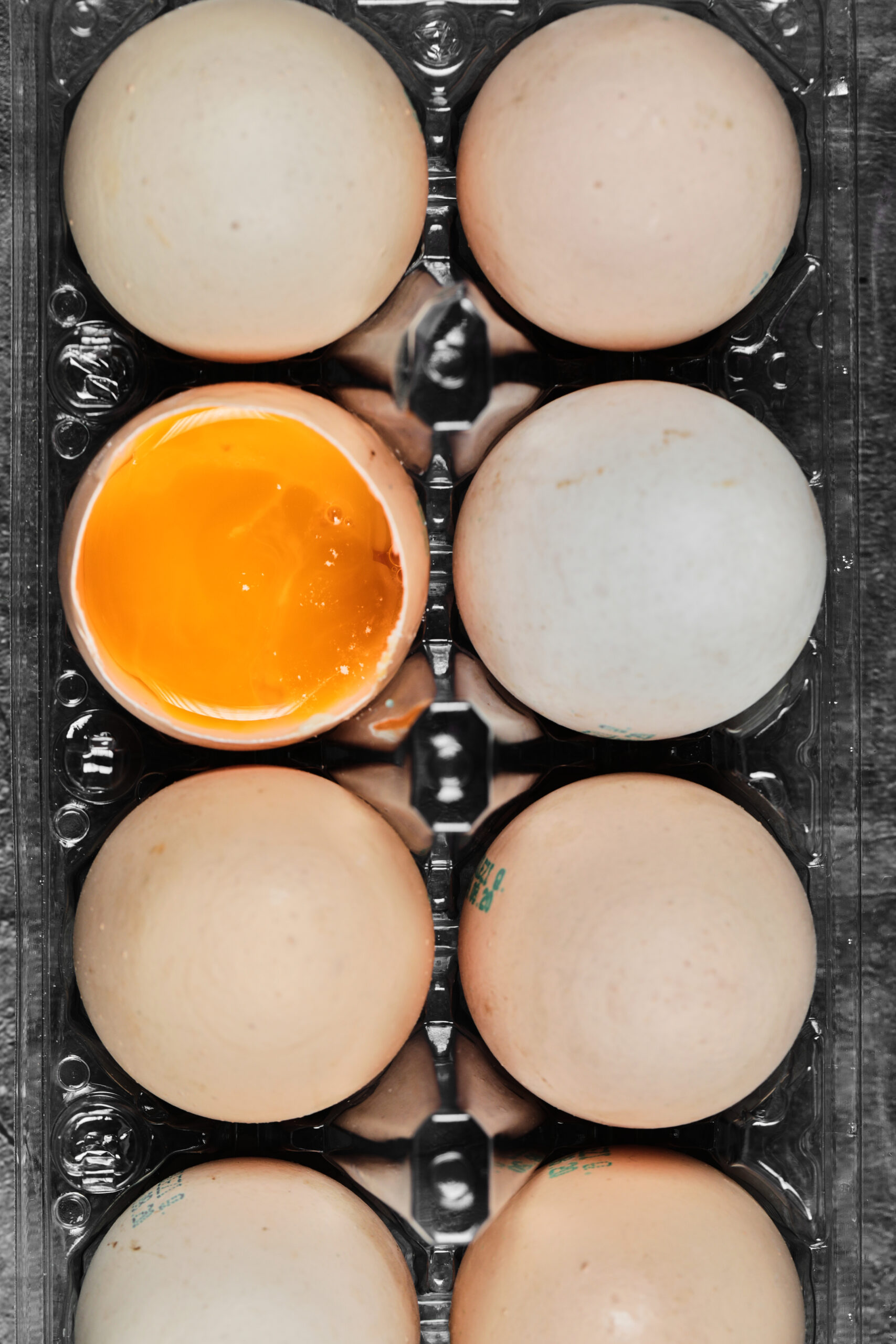 Flat lay closeup view raw and soft boiled eggs on plastic box. High quality photo